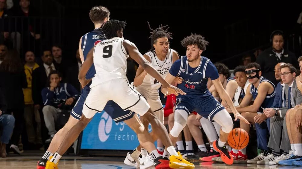 <p>Guard George Washington III dribbles around Rams players. Courtesy of Richmond Athletics.&nbsp;</p>