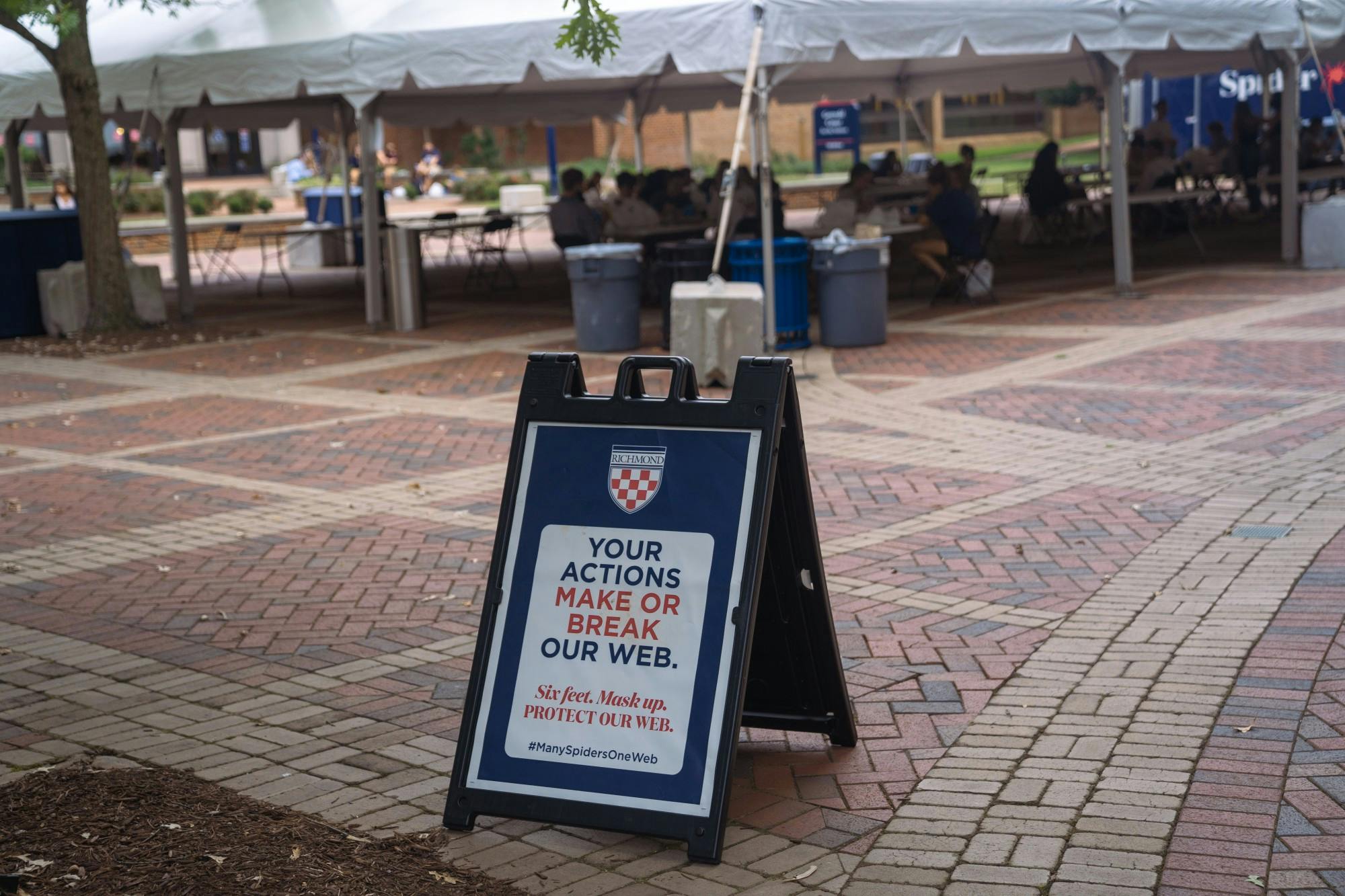 A sign reminding students to adhere to distancing guidelines stands outside the cafeteria tent in the forum on Sept. 8.