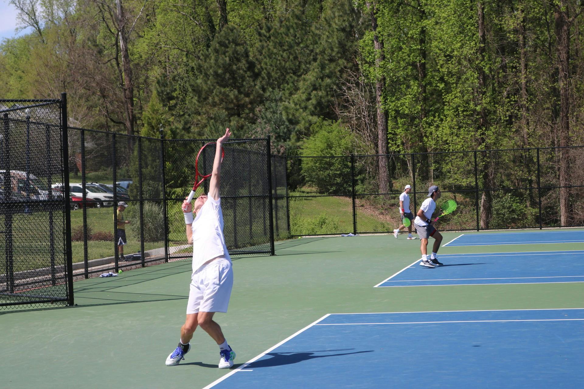 Sophomore Daniel Kliebhan raises his racket at the home game against St. Bonaventure University on April 15.