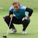 Senior Lauren Folgosa lines up a putt during practice at the Spider Golf Facility.