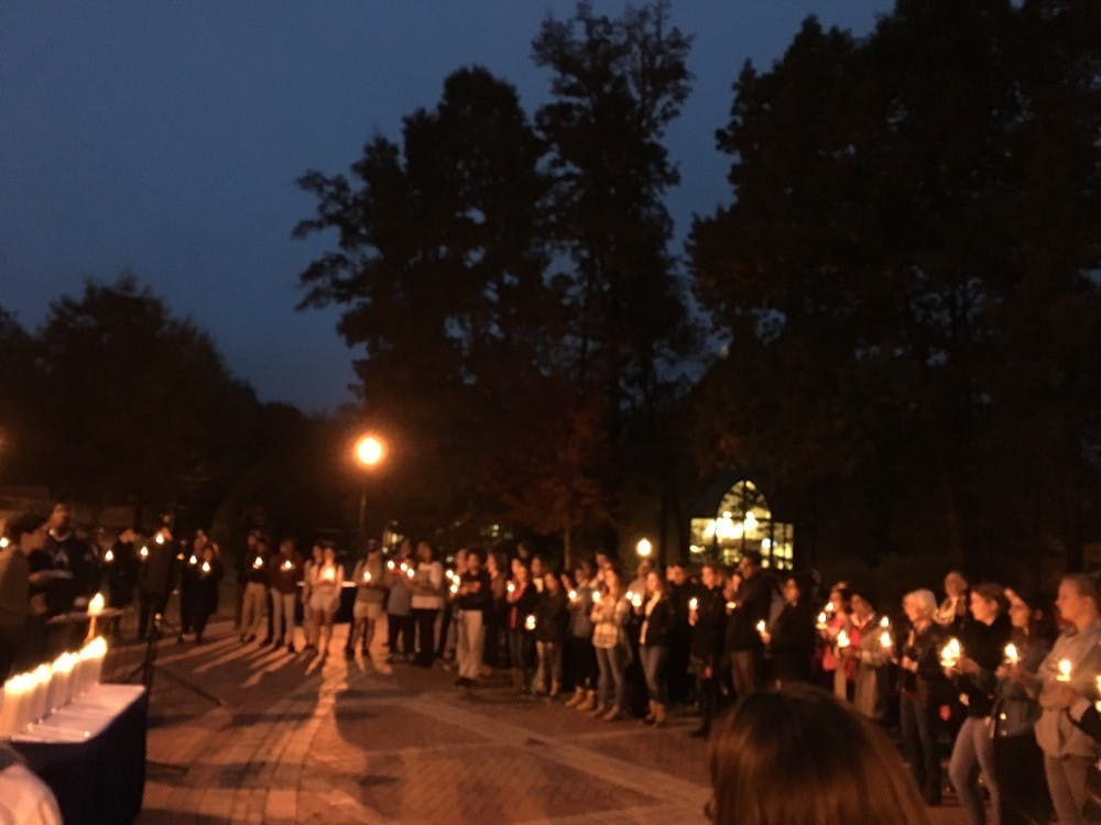 Students and community members reflect in memory of recent victims of violence as a cappella group Couer-du-Roi sings "Imagine" by John Lennon.