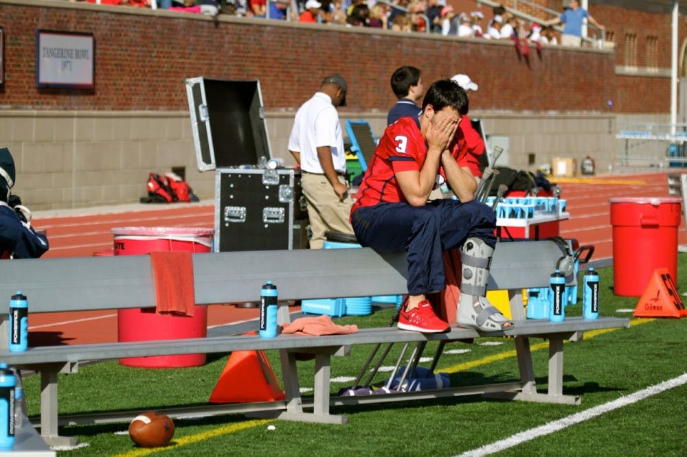 <p>Quarterback Michael Strauss watching last weekend's Homecoming game from the sidelines.</p>