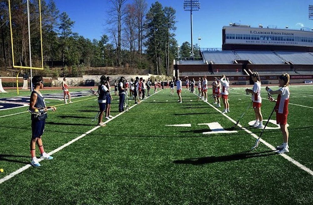 <p>Richmond women's lacrosse players work with local students from the&nbsp;Anna Julia Cooper Episcopal School. Photo courtesy of Mary Simpson.</p>