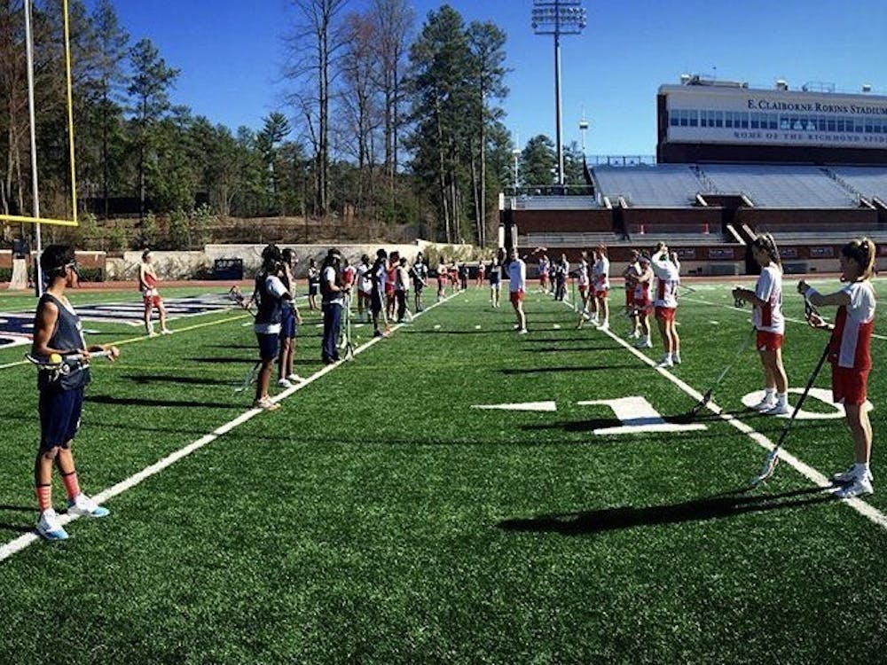 Richmond women's lacrosse players work with local students from the Anna Julia Cooper Episcopal School. Photo courtesy of Mary Simpson.