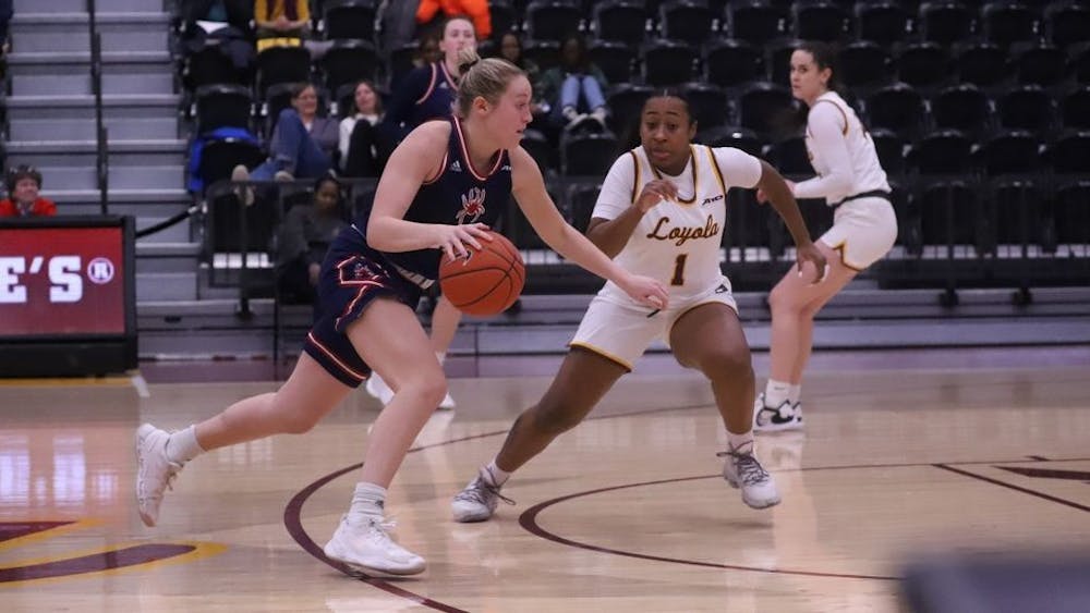 <p>Sophomore guard Katie Hill dribbles past a Loyola University Chicago player during away game on Jan 4. at the Gentile Arena in Loyola University Chicago's campus. Photo courtesy of Richmond Athletics.&nbsp;</p>