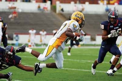 Tremayne Graham (23) tackles Tulsa's running back (center). UR's David Horton (right).