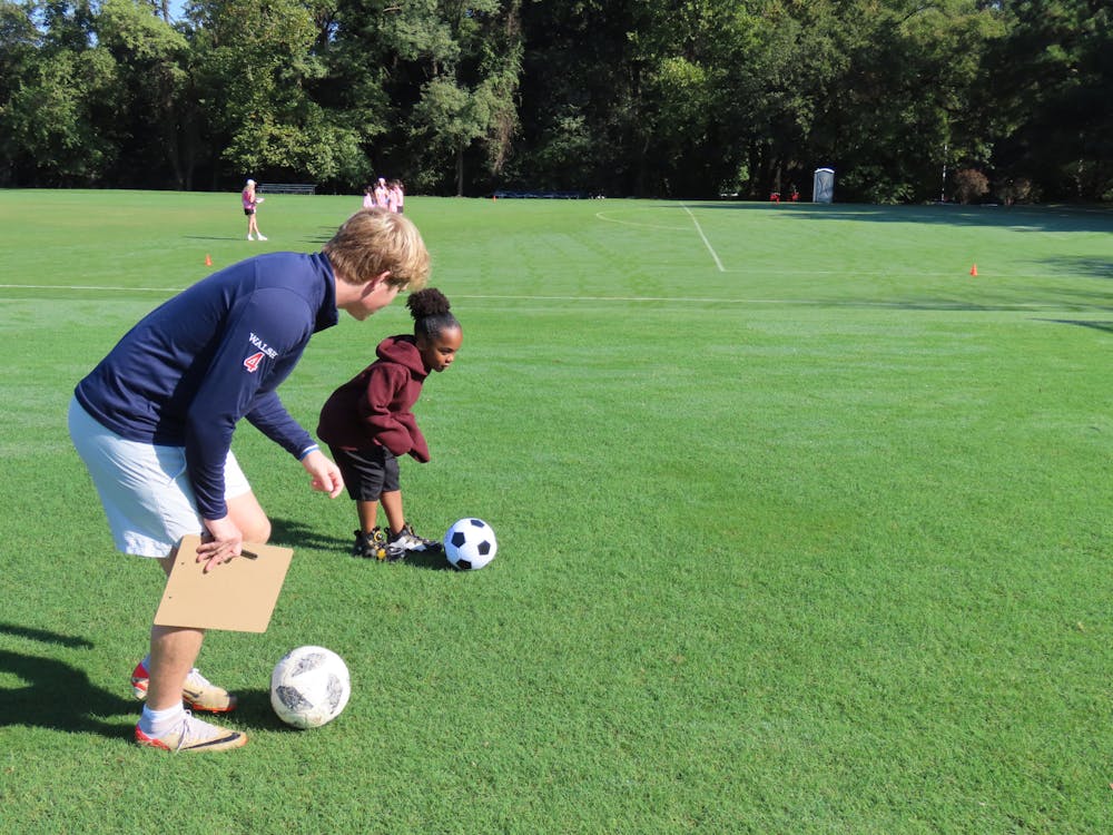 <p>Sophomore Gordon Walsh helps a child hone their soccer skills. Photos courtesy of Jack Raiz.</p>