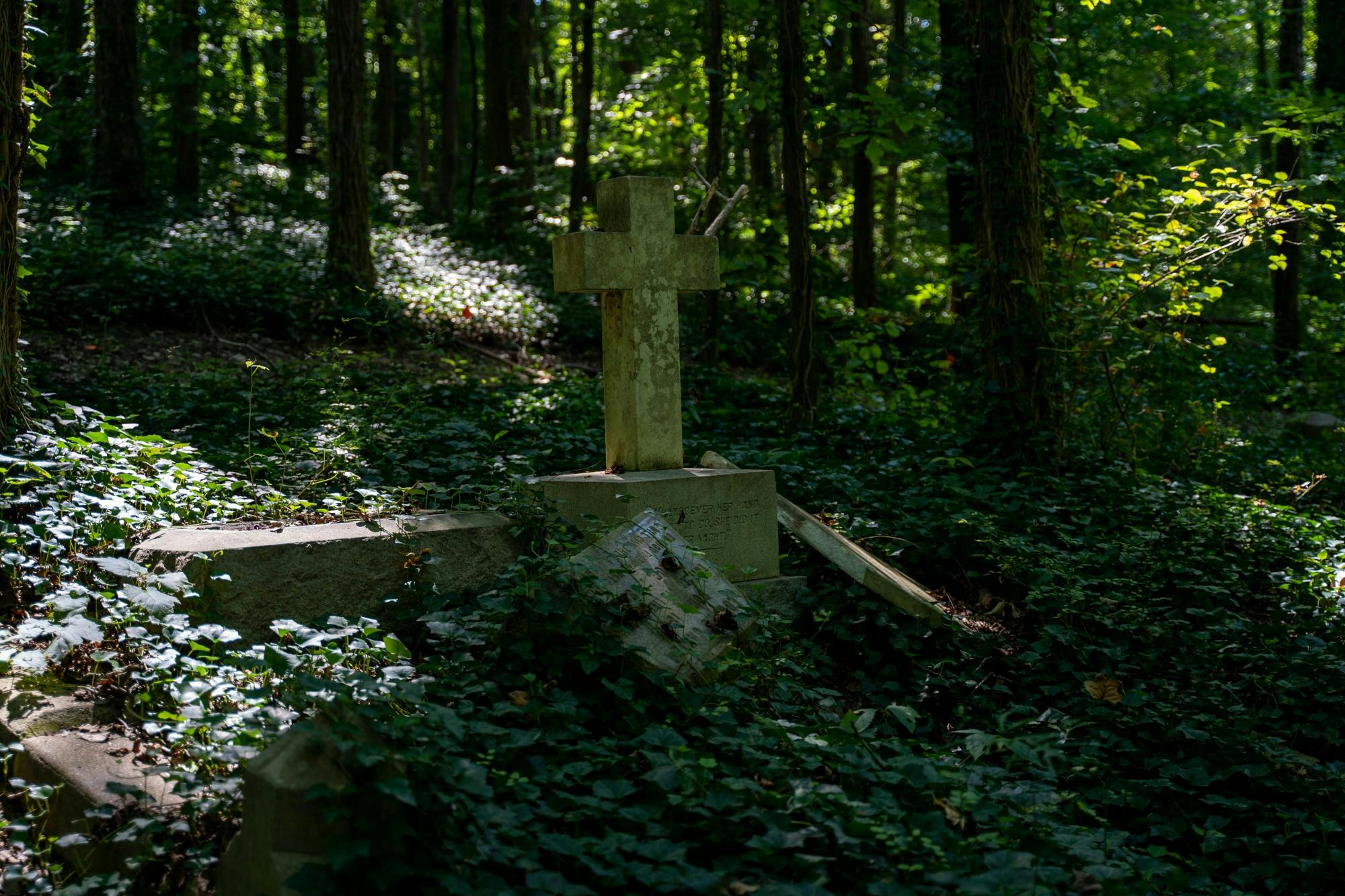 As nature reclaims the land, a century-old cross stands alone among the ruins of several forgotten graves at the Evergreen Cemetery on August 31, 2019. &nbsp;