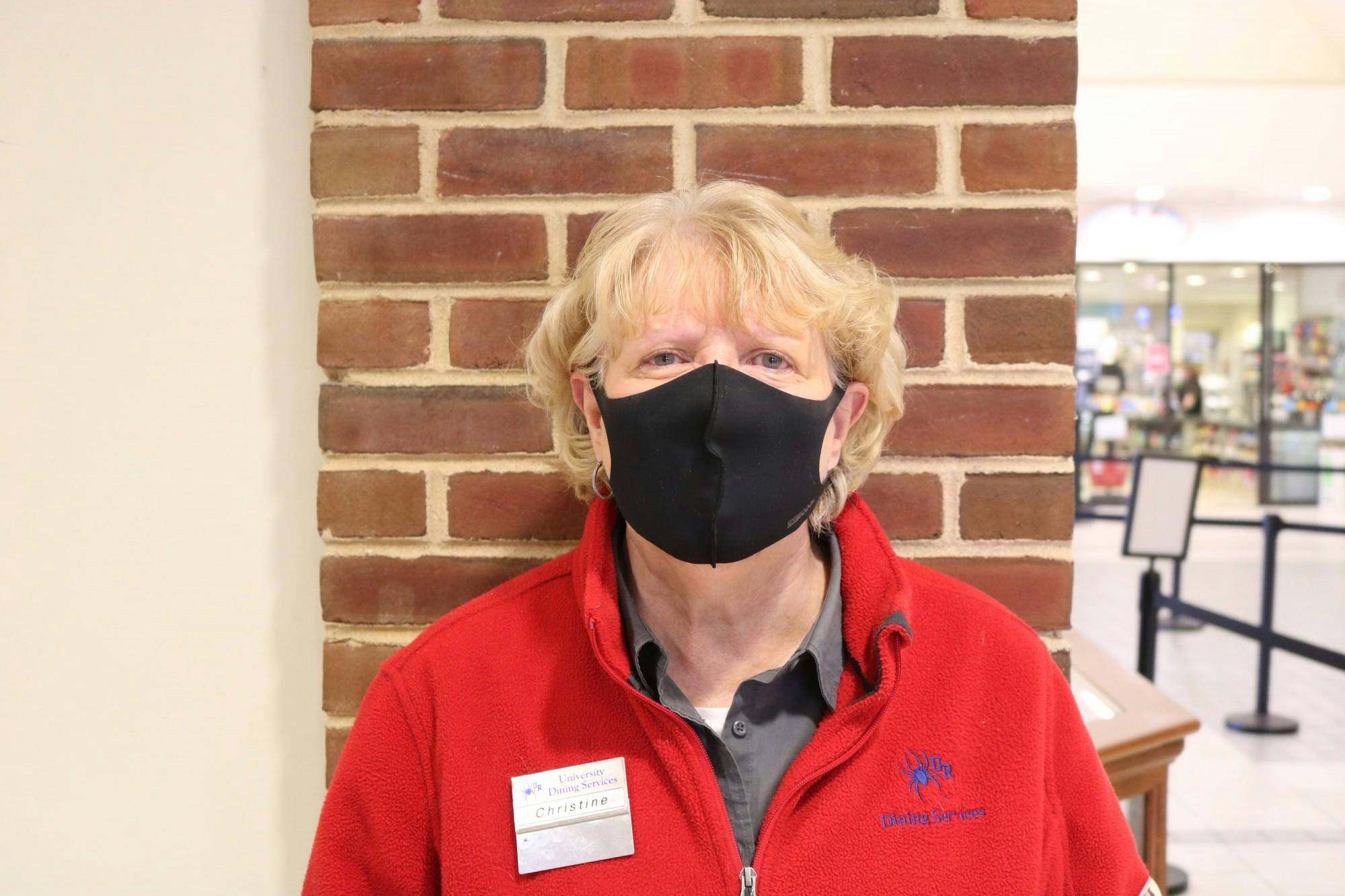 Christine welcomes students to the Heilman Dining Center with a hello.