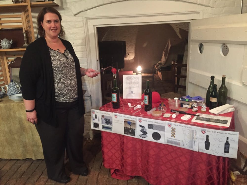 <p>Biology professor Angie Hilliker demonstrates her method of wine extraction at the John Marshall House.</p>