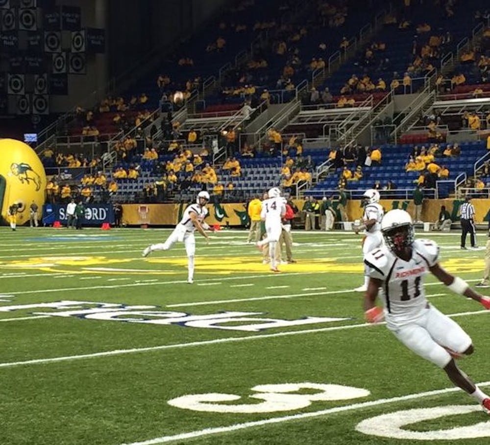 <p>Quarterback Kyle Lauletta works with Reggie Diggs in warmups from the FargoDome. Photo courtesy of Spider Athletics.</p>