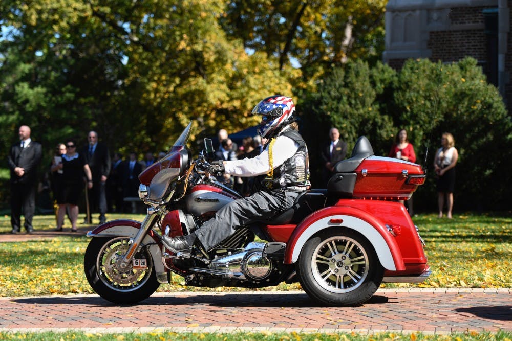 Onlookers watch as a freedom rider makes his way into the Forum in celebration of E. Bruce Heilman's life on Sunday, Oct. 27, 2019.