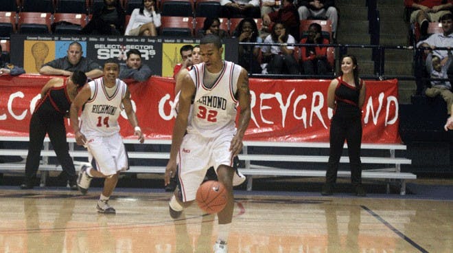 Senior running back Josh Vaughan (No. 32) takes a handoff from redshirt junior quarterback Eric Ward (No. 11) during a game in which the Spiders lost 16-0 to the University of Virginia Cavaliers. (Jeff Bardsley/The Collegian)