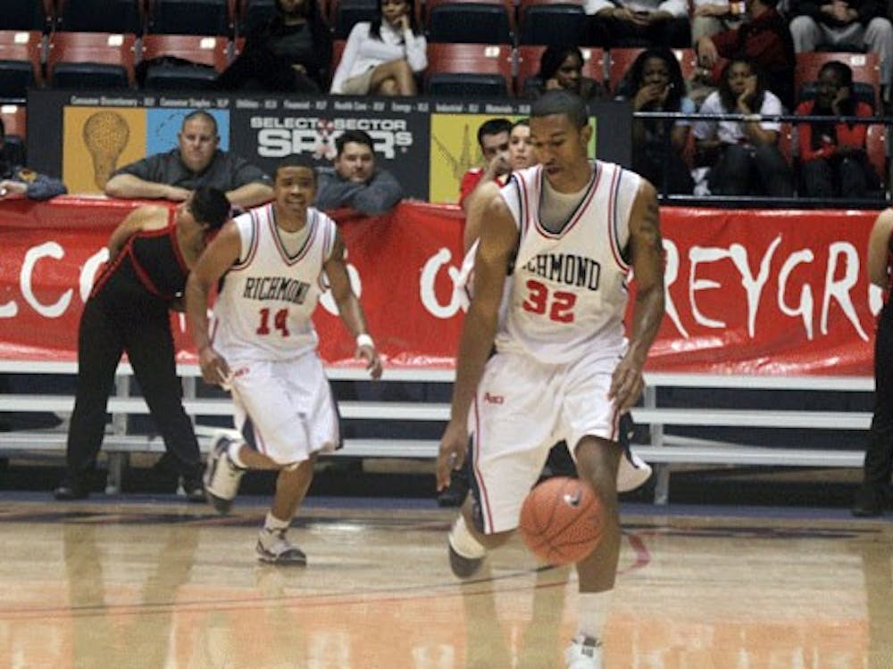 Senior running back Josh Vaughan (No. 32) takes a handoff from redshirt junior quarterback Eric Ward (No. 11) during a game in which the Spiders lost 16-0 to the University of Virginia Cavaliers. (Jeff Bardsley/The Collegian)