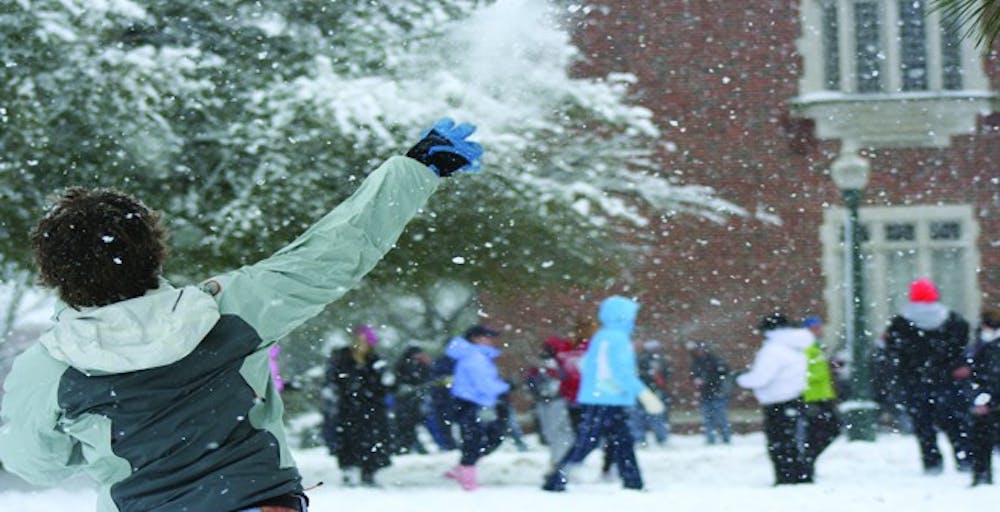 A student hurls a snowball at the crowd Monday afternoon on the Westhampton Green.