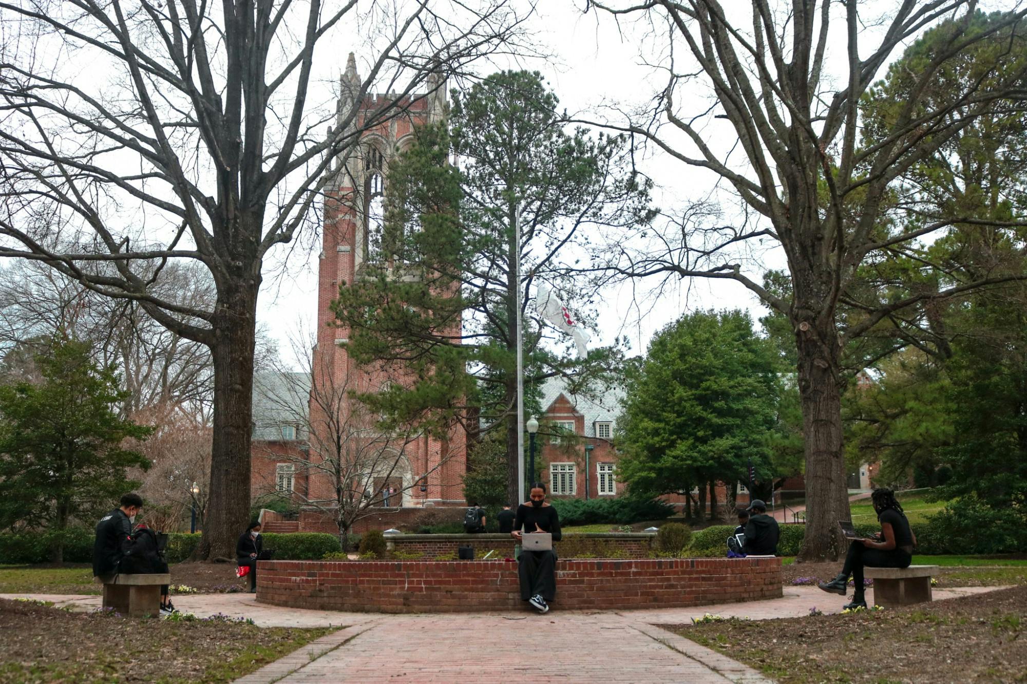 Physically-distanced students gather by the UR flag pole.