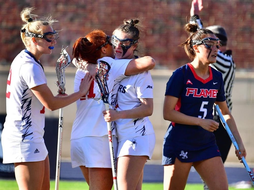 Women's lacrosse players congratulate one another during game against Liberty University on Feb. 8. Photo courtesy of Richmond Athletics.&nbsp;