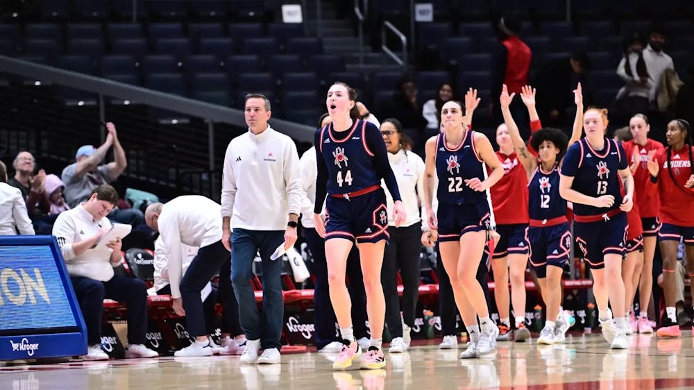 The Spiders Women's Basketball Team with junior forward Maggie Doogan cheering in front. Courtesy of Richmond Athletics.