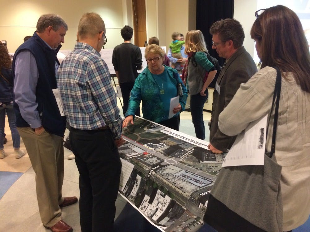 <p>Bike Walk RVA forum attendees&nbsp;look over a map of the new road designs, which plan to&nbsp;construct 25 miles of bike lanes throughout the city of Richmond.</p>