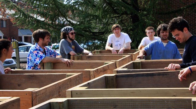 Tim Adkins and Sam Sheppard of Backyard Farmer collaborated with students from Green UR and UR Rot on Sunday to create a composting unit near the 1800 block of the University Forest Apartments