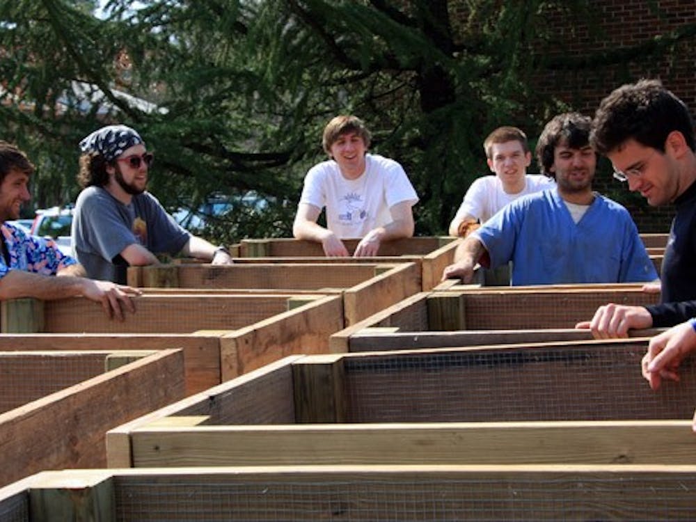 Tim Adkins and Sam Sheppard of Backyard Farmer collaborated with students from Green UR and UR Rot on Sunday to create a composting unit near the 1800 block of the University Forest Apartments