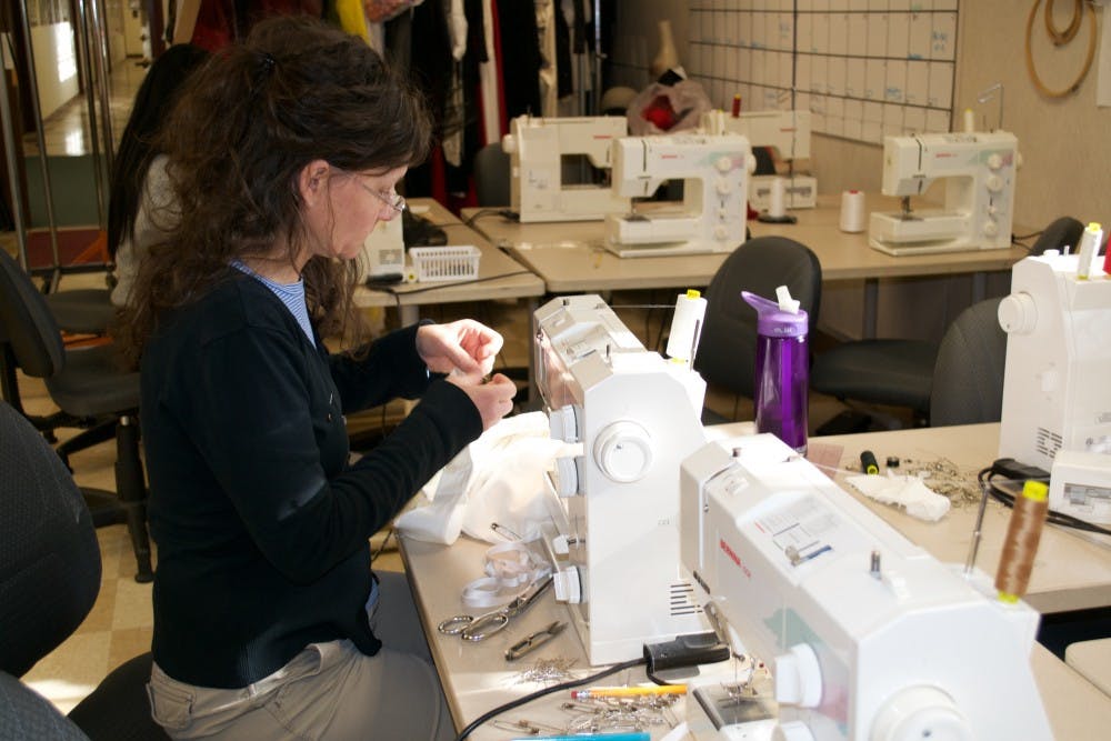 Heather Hogg, assistant director of costume, gets to work sewing a costume.