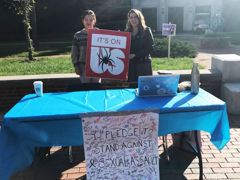 Helen Li (left)&nbsp;and Caroline McNamara, members of the It's On Us campaign,&nbsp;stand together during the Fall Week of Action to help end sexual assault on campus.&nbsp;