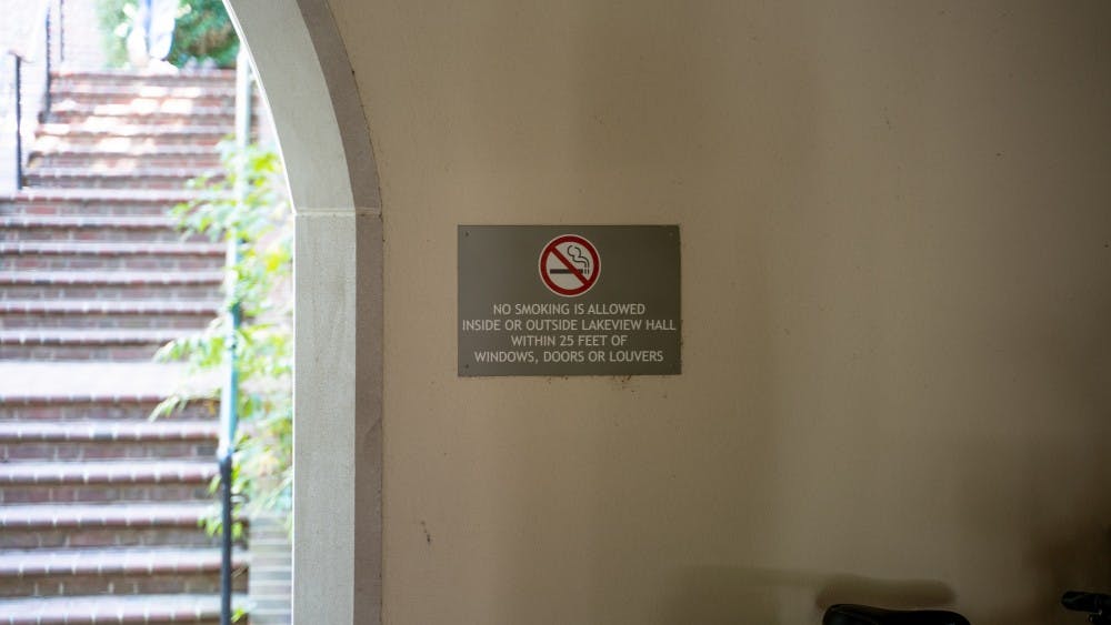 A sign outside Lakeview Hall explains the distance a person must be from the building to smoke.