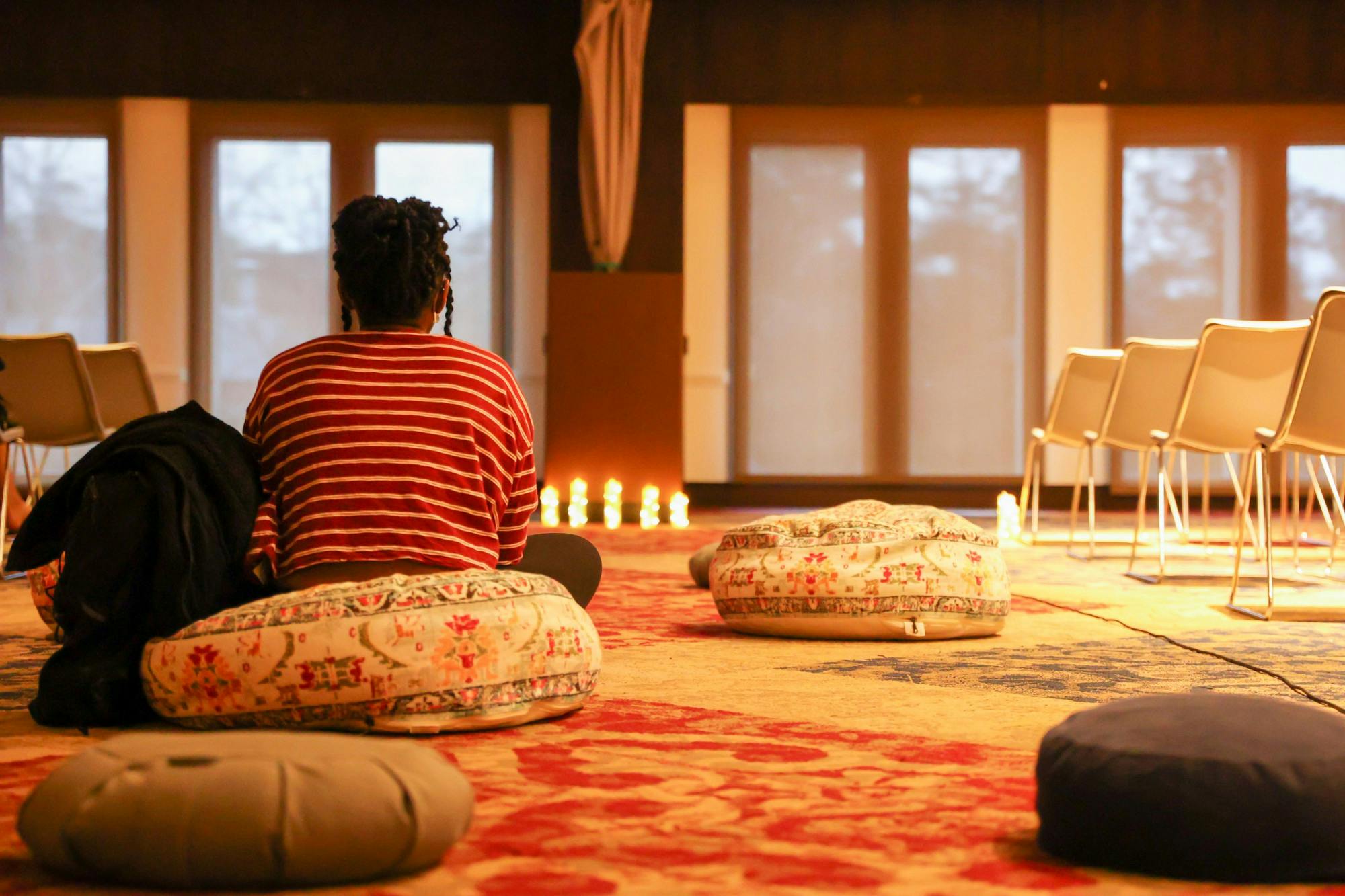 A person sits on a pillow at the Take Back the Night speak-out event in the Alice Haynes Room on April 4.