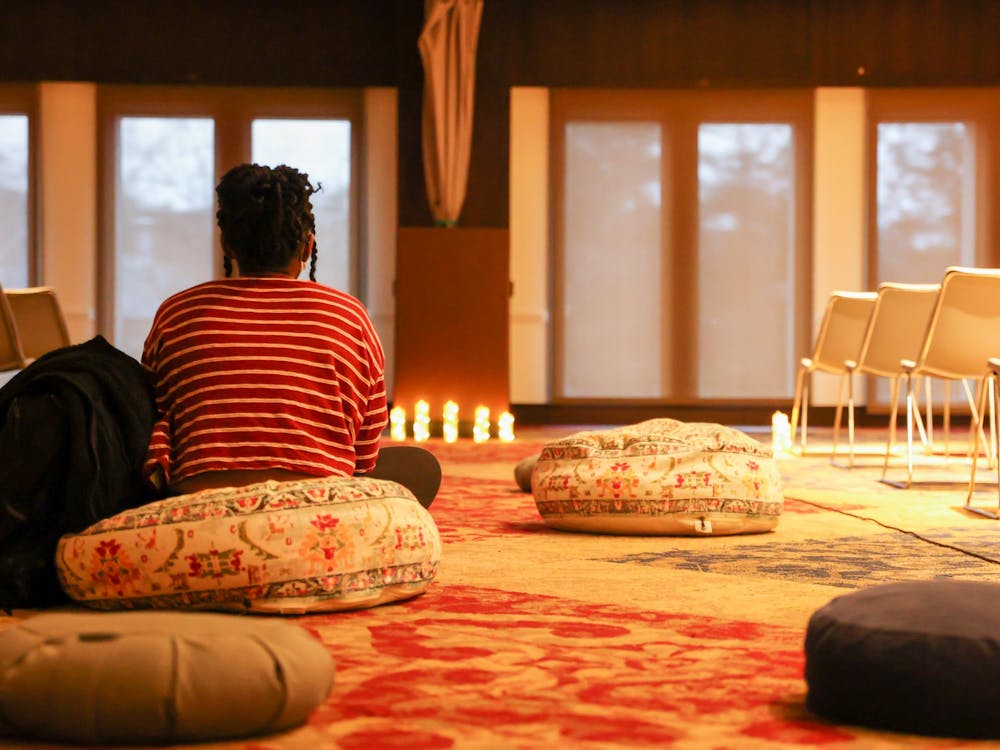 A person sits on a pillow at the Take Back the Night speak-out event in the Alice Haynes Room on April 4.