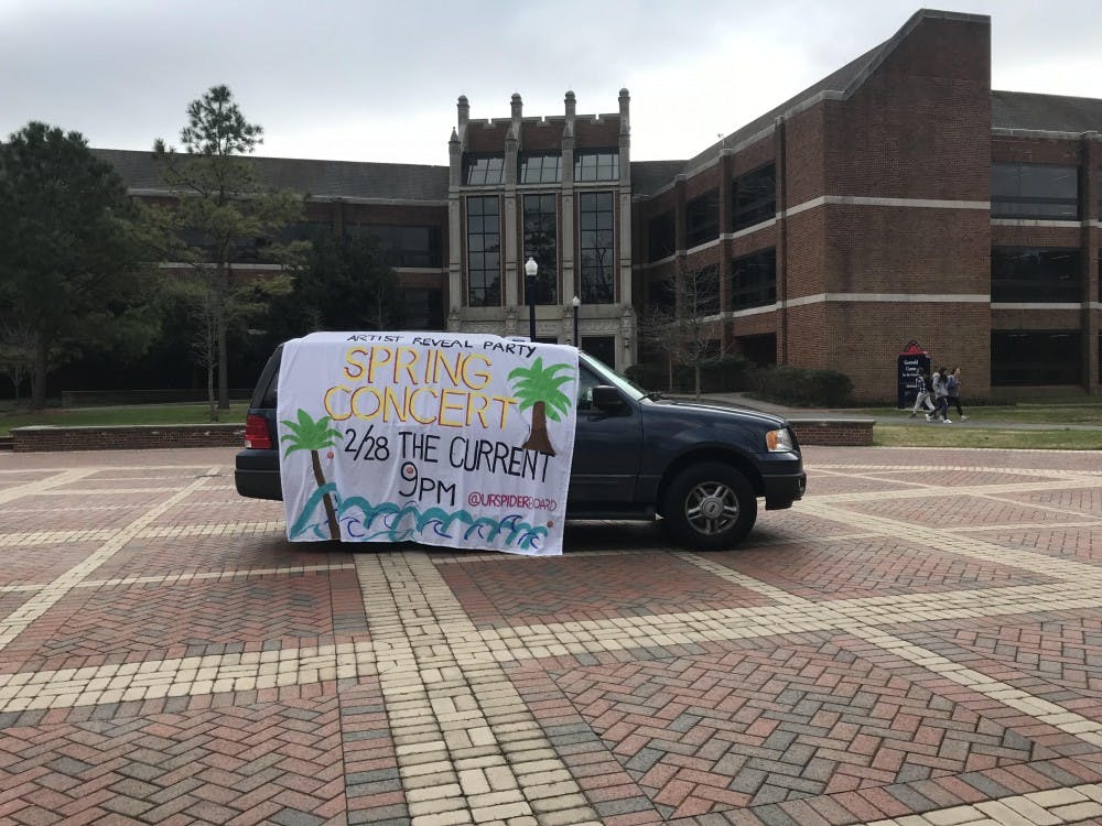 SpiderBoard parked a car in the Forum with a banner to advertise the spring concert reveal party on Thursday night.&nbsp;