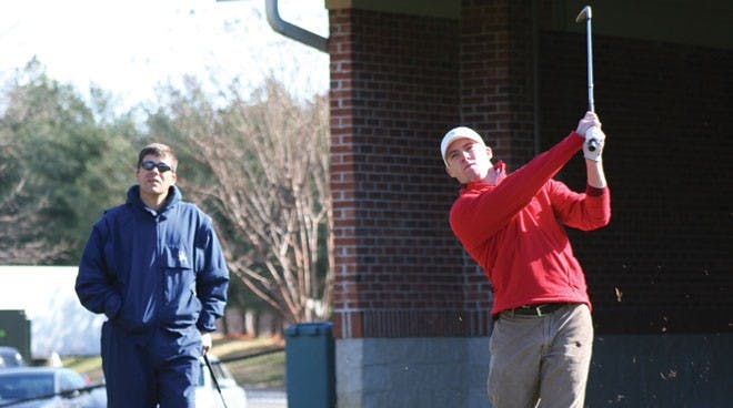 Senior Lawrence Lessing worked on his shot Friday afternoon as Coach Adam Decker looked on.