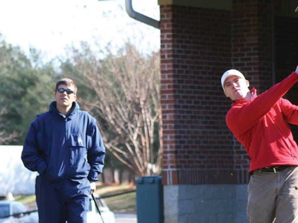 Senior Lawrence Lessing worked on his shot Friday afternoon as Coach Adam Decker looked on.