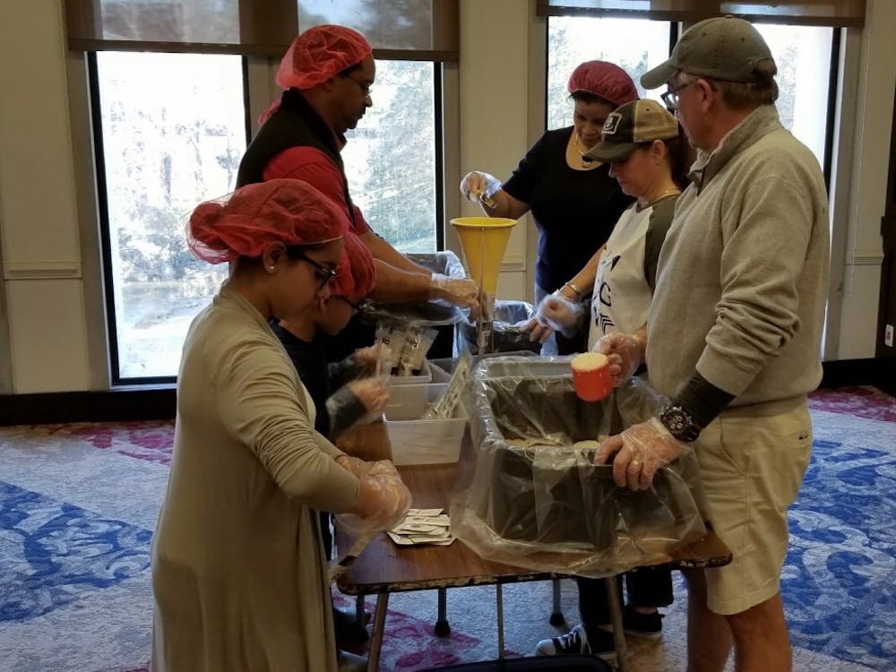 Melania Lambert,11 (bottom left), Benjamin Lambert IV, 7, Mark Parson, Rhonda Parson, Laura Grivetti and Don Grivetti prepare meal bags during the Rise Against Hunger meal packaging event.