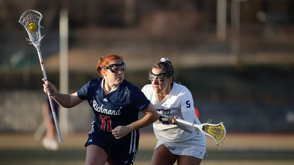 <p>Senior attacker Colleen Quinn weaves around JMU player. Courtesy of Richmond Athletics</p>