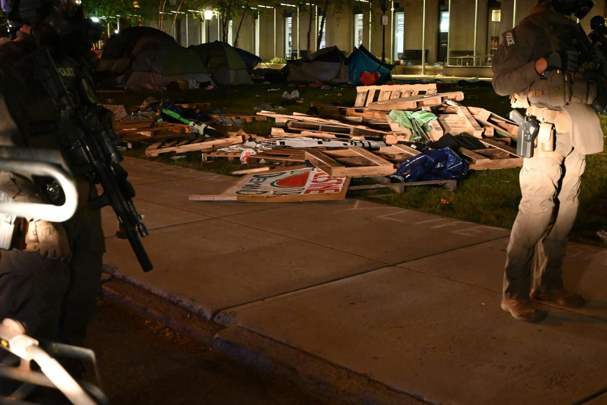 Remnants of barrier created by protesters that was torn down by police along with signs taken from the encampment.