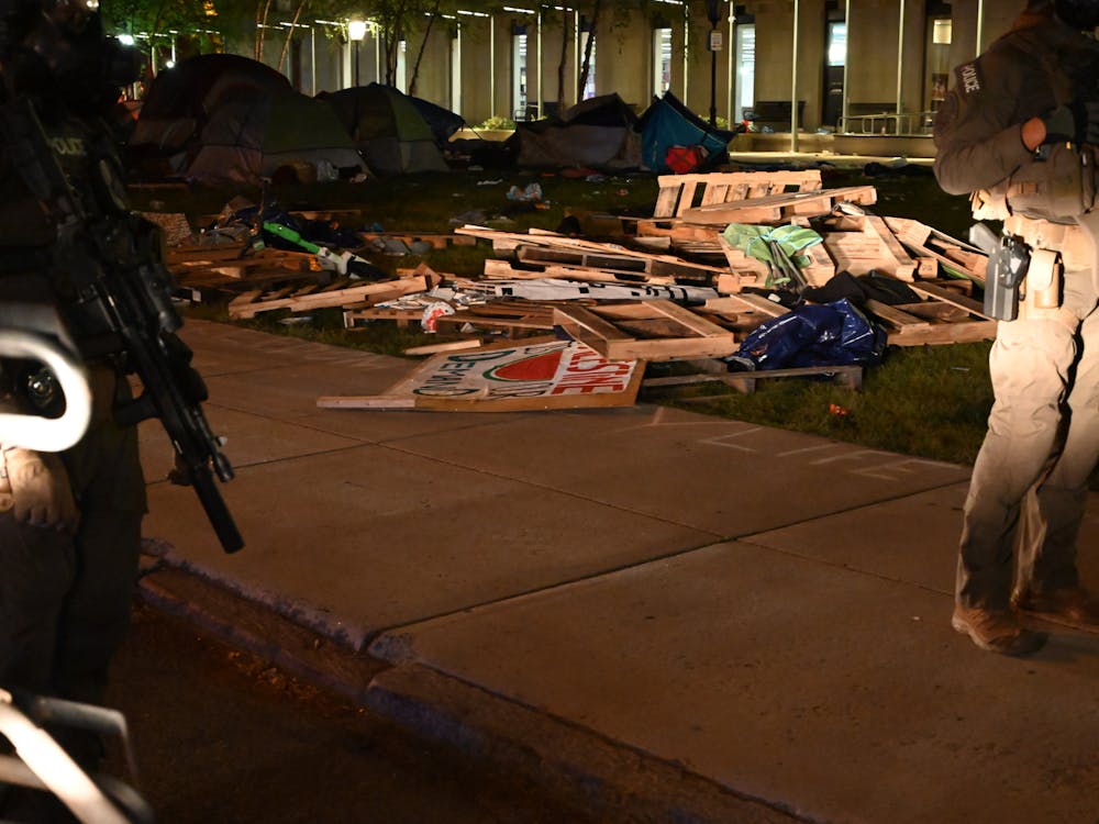 Remnants of barrier created by protesters that was torn down by police along with signs taken from the encampment.