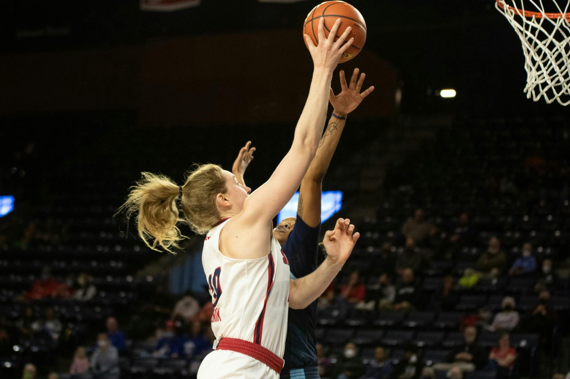 Sophomore forward Addie Budnik takes it to the basket at the Feb.19 game against Rhode Island University.