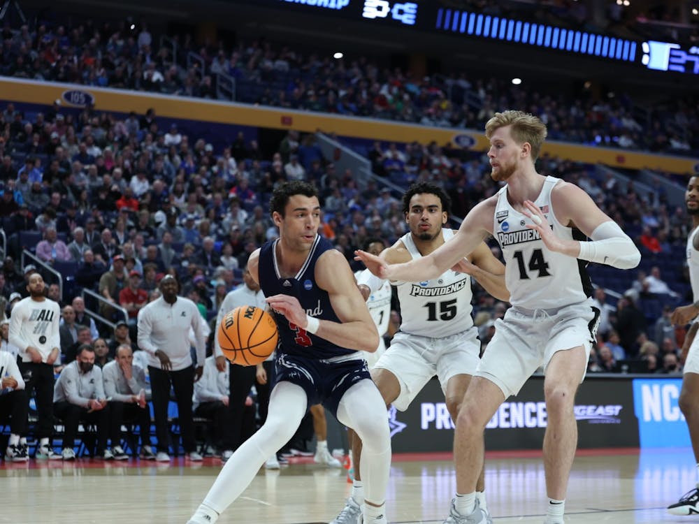 Junior forward Tyler Burton defends the ball from Providence College players at the second round of the NCAA tournament on March 20 at the KeyBank Center in Buffalo, New York. Photo courtesy of Richmond Athletics.