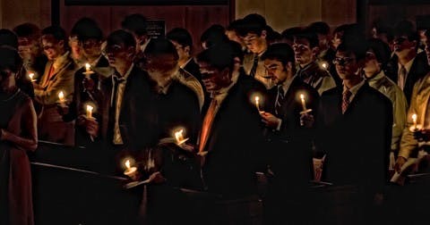 Freshmen sing the alma mater and hold candles during investiture