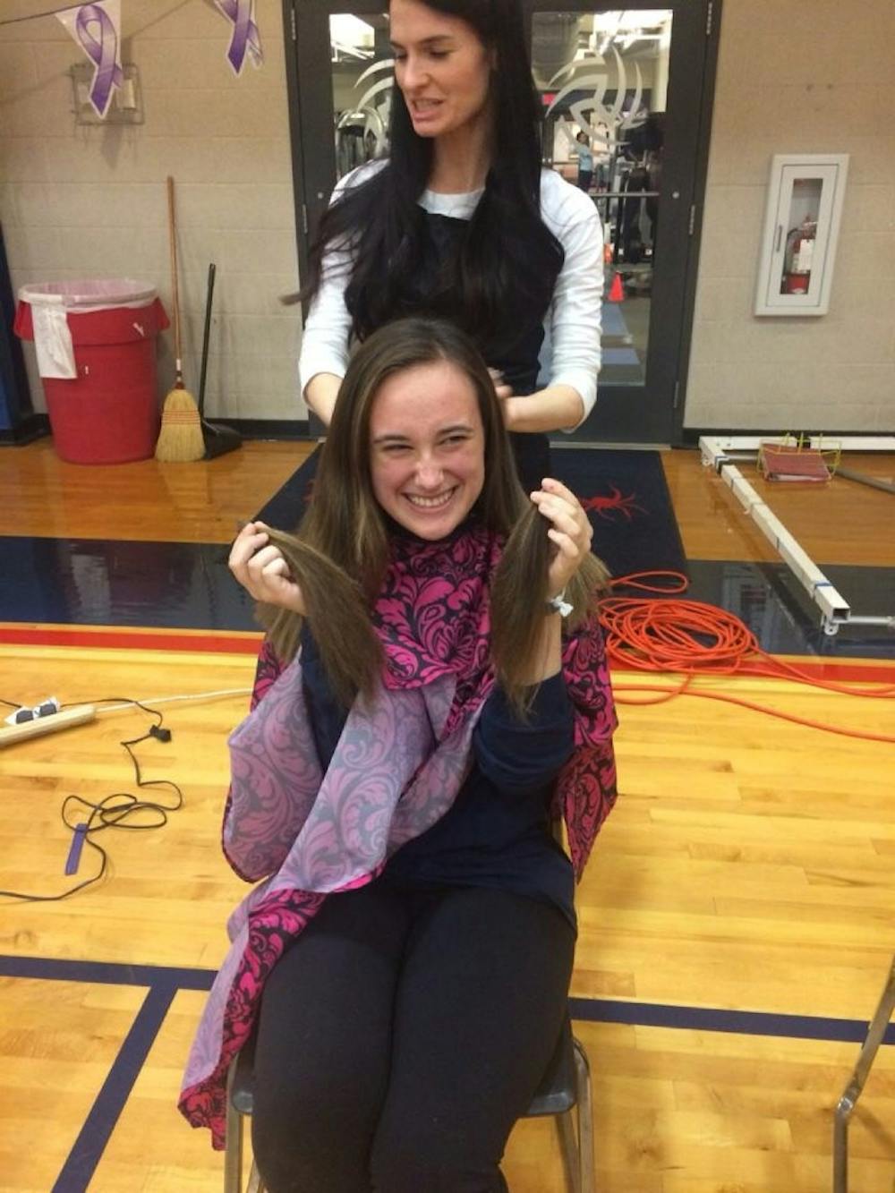 <p>Freshman Carly Green donates her hair at the Pantene Beautiful lengths station.</p>