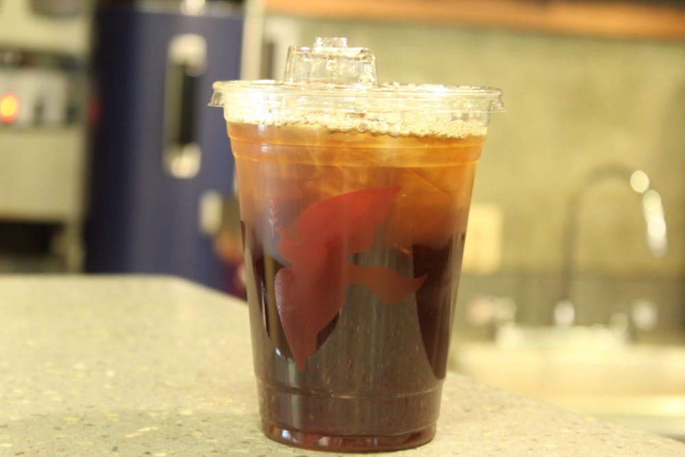 An iced La Colombe coffee sits on the counter for pickup.