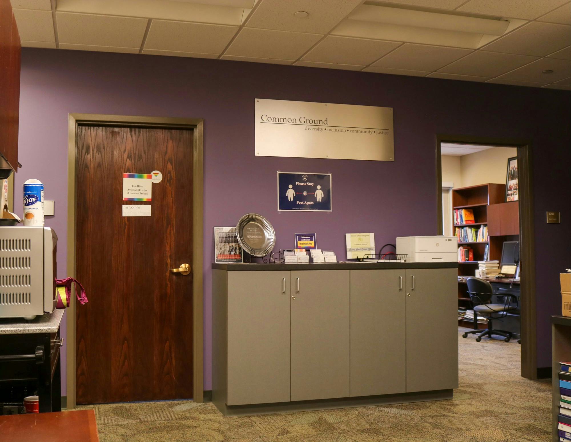 The sign denoting the Office of Common Ground stands out amongst a sea of purple paint.