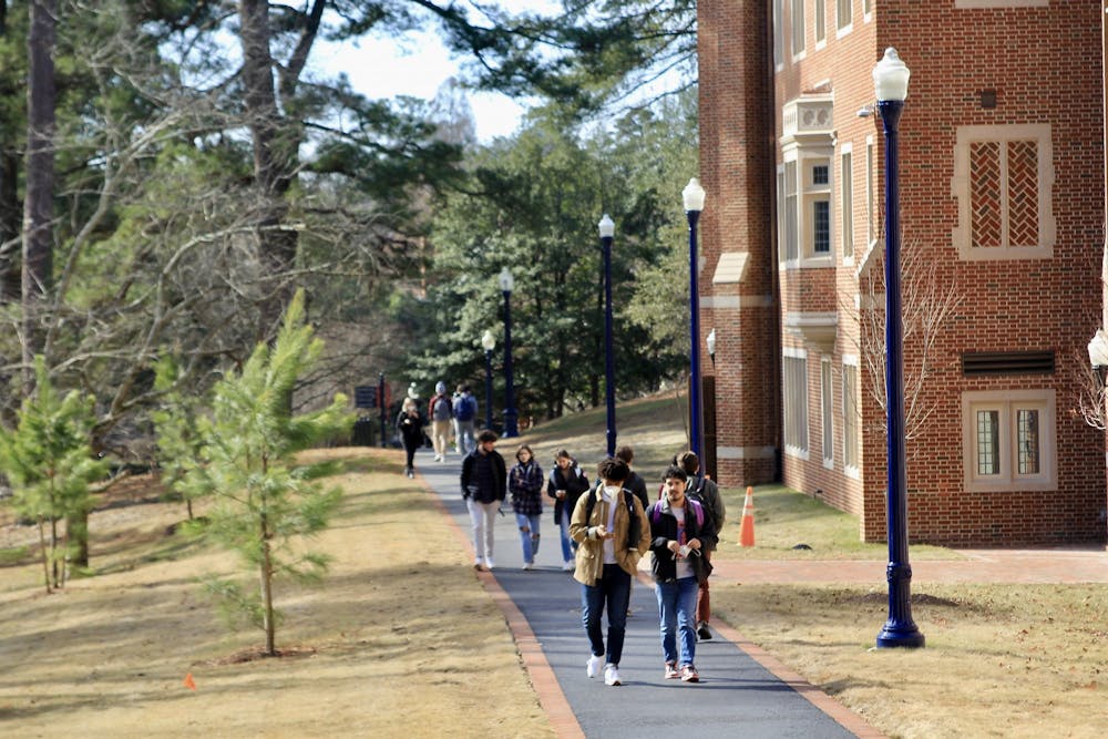 Students walk on the path next to Ryland Hall.&nbsp;