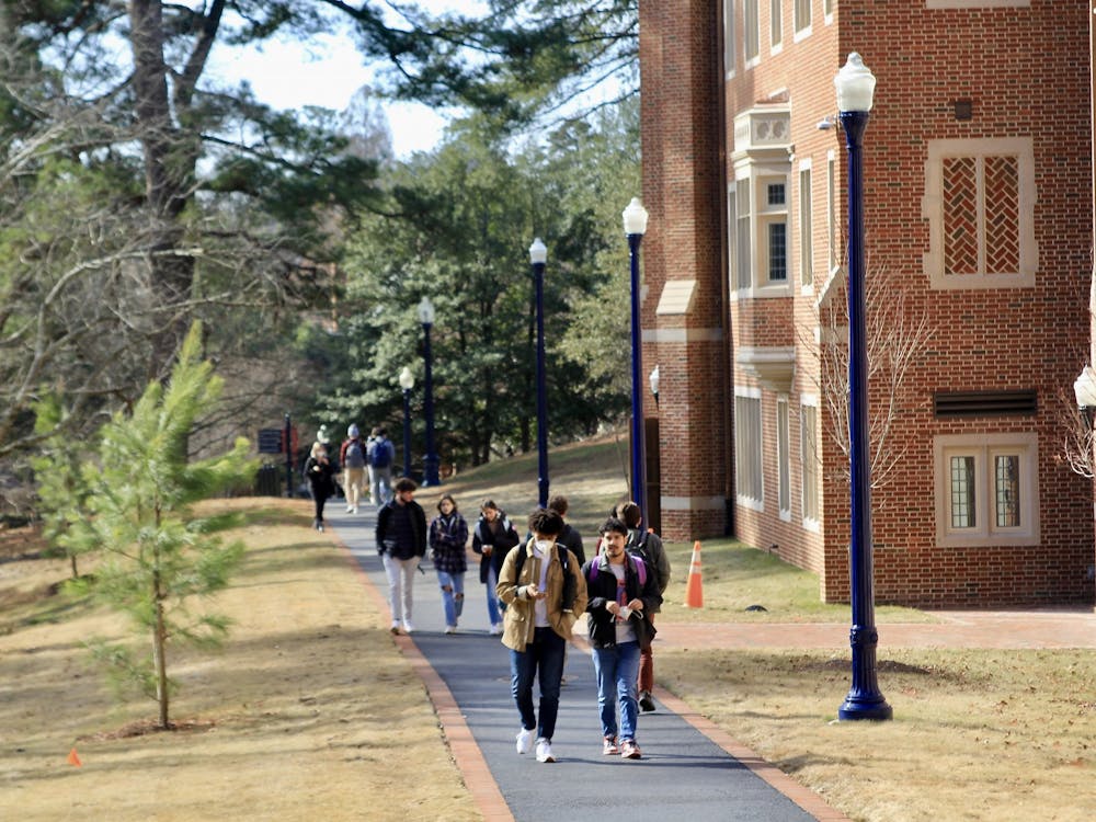 Students walk on the path next to Ryland Hall.&nbsp;