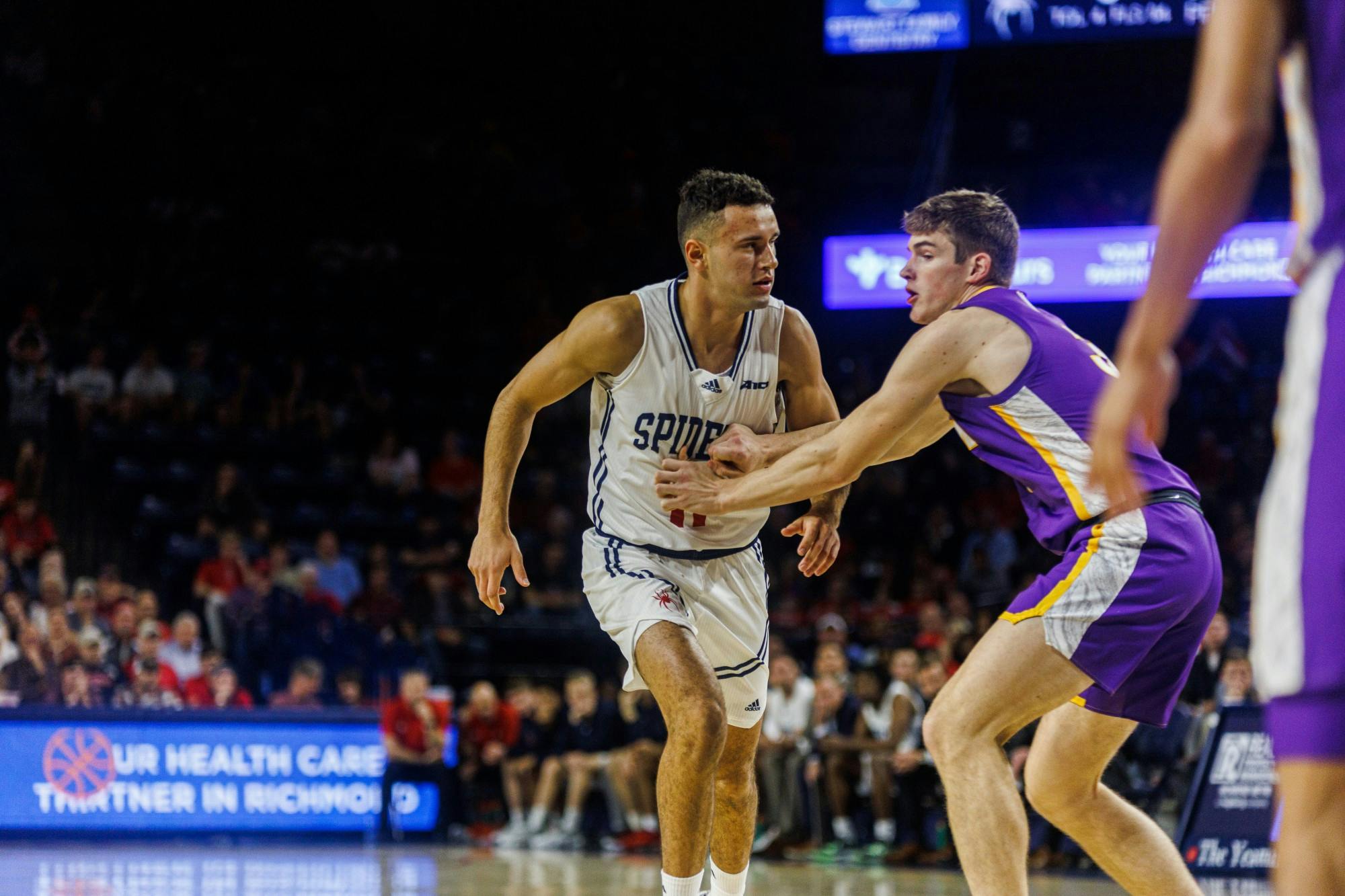 Sophomore guard Jason Roche tries to shake off his defender while being face guarded at the game against University of Northern Iowa on Nov. 11 in the Robins Center.