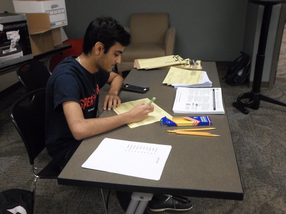 <p>Sophomore Haamid Shaikh looks over a tax return at the VITA center at UR Downtown.</p>