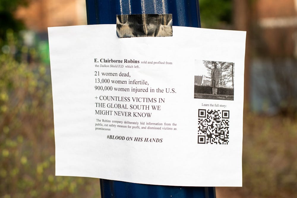 A flyer taped to a lamp post outside of the Carole Weinstein International Center stating that "E. [Claiborne] Robins sold and profited from from the Dalkon Shield IUD which left... 21 women dead, 13,000 women infertile, and 900,000 injured."