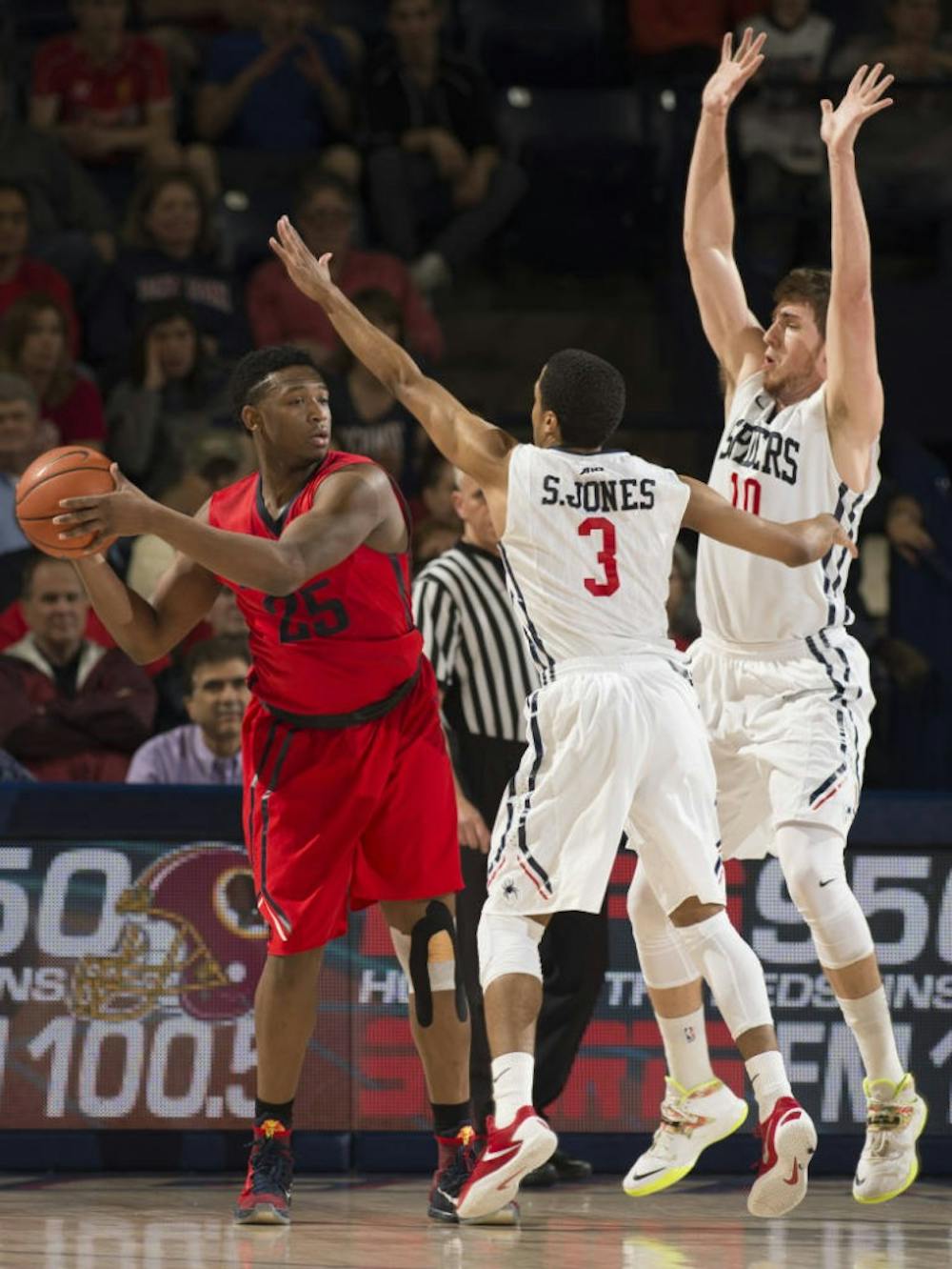 <p>ShawDre' Jones and TJ Cline defend Dayton's Kendall Pollard, who helped the Flyers to a victory against the Spiders in the A-10 Quarterfinals&nbsp;| Photo courtesy of Richmond Athletics</p>