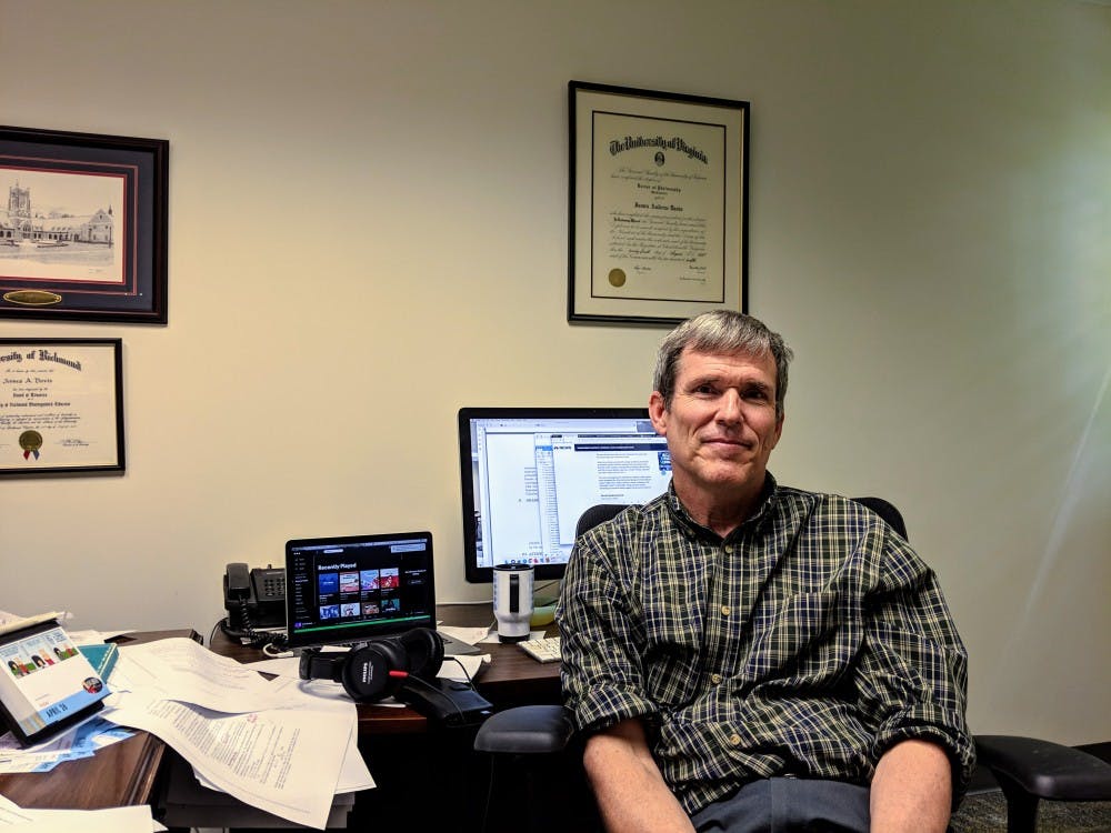 <p>Mathematics professor James Davis sits in his office.</p>